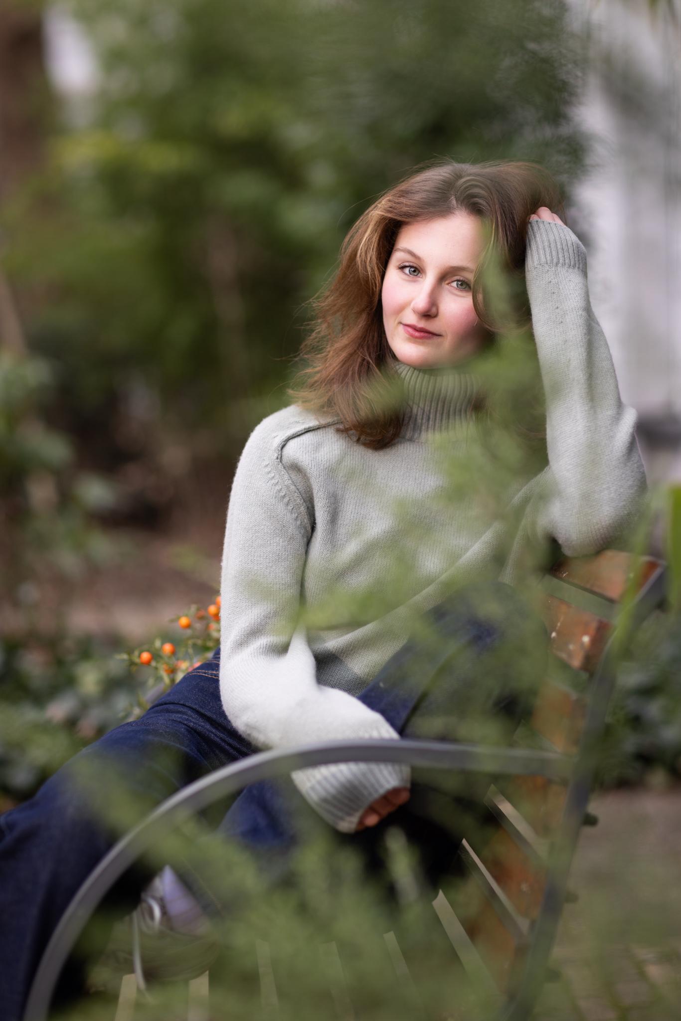 Dromerig portret tussen groen – Portretfotografie buiten Portret van jonge vrouw achter zachte begroeiing, dromerig buitenportret.